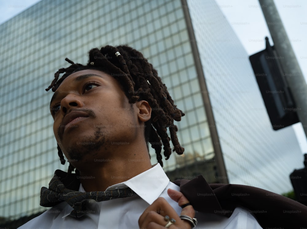 a man with dreadlocks wearing a white shirt and tie