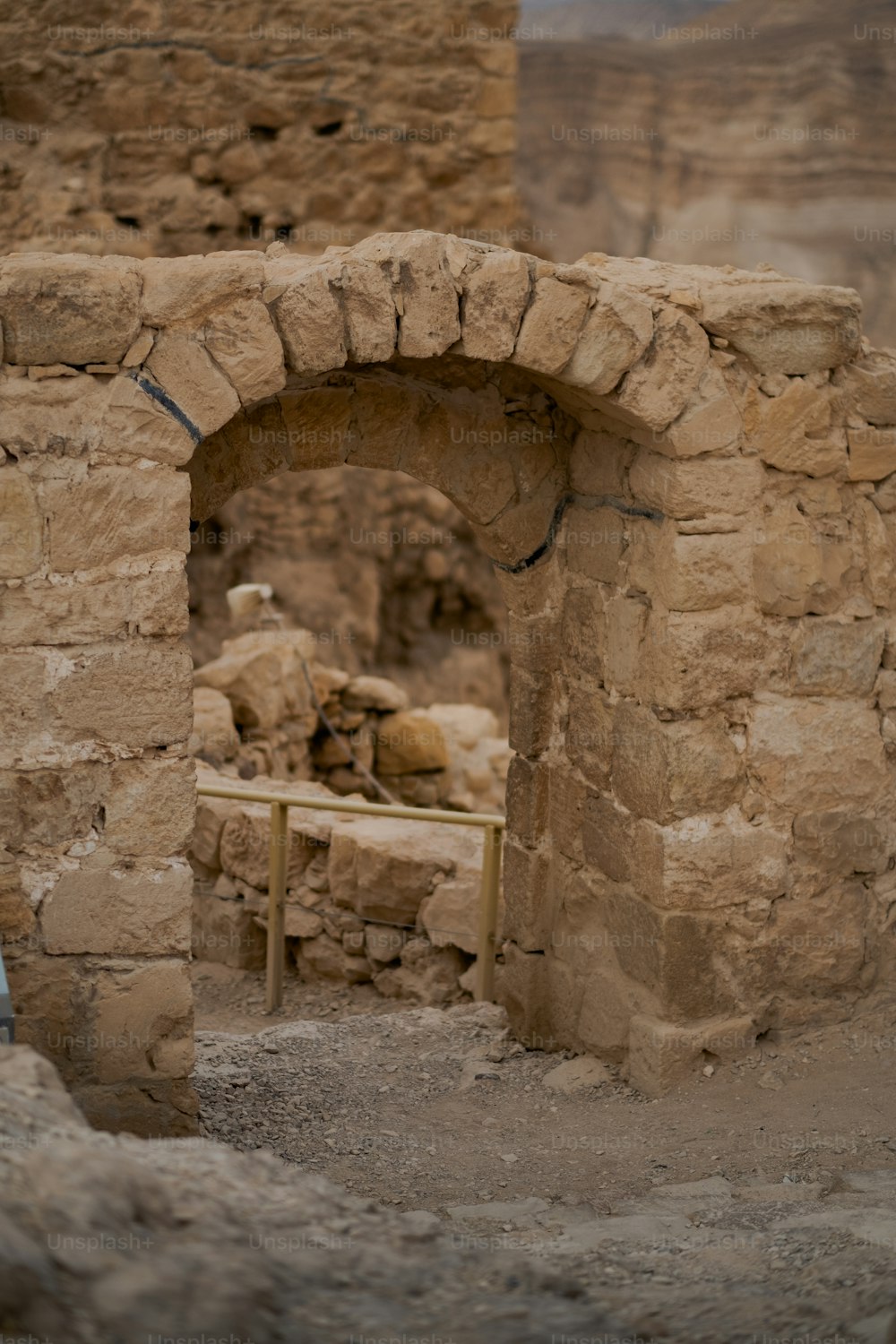 a stone arch with a bench in the middle of it