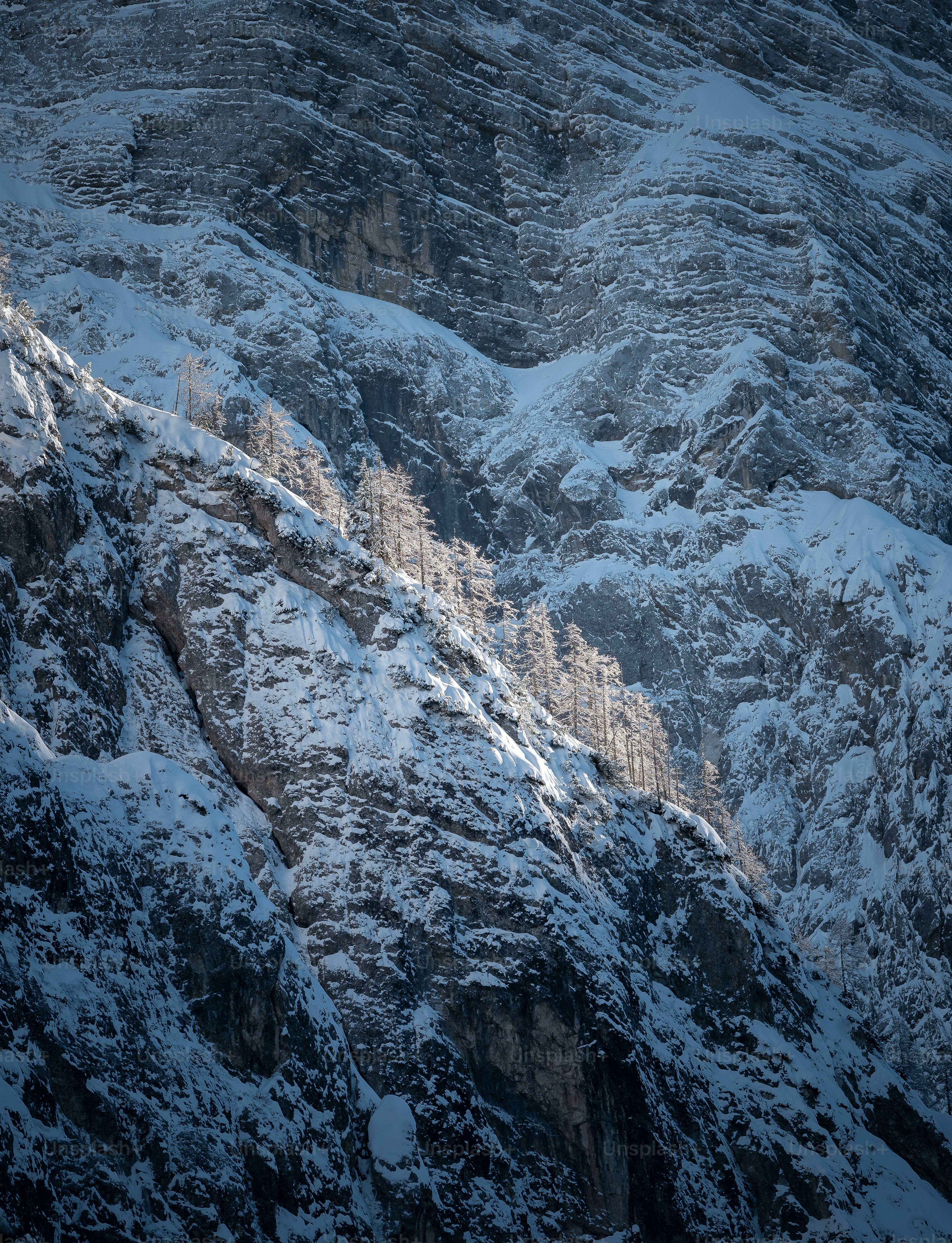 A mountain covered in snow and clouds under a blue sky photo ...