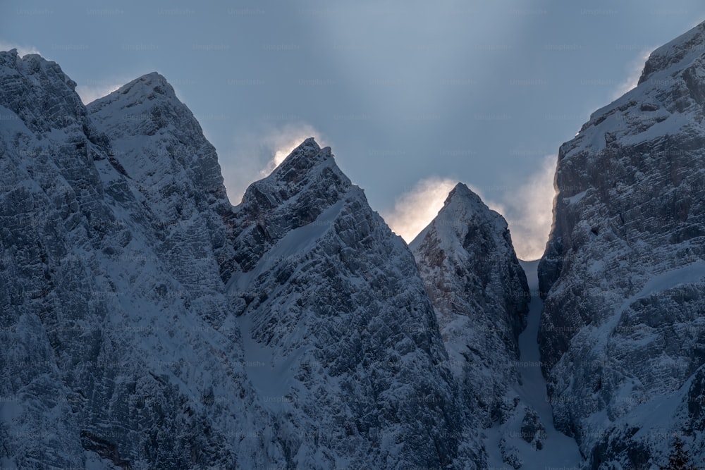 Un grupo de montañas cubiertas de nieve bajo un cielo nublado