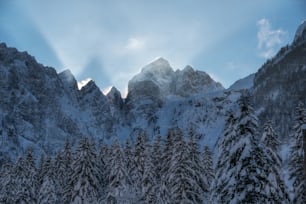 the sun shines through the clouds over the mountains