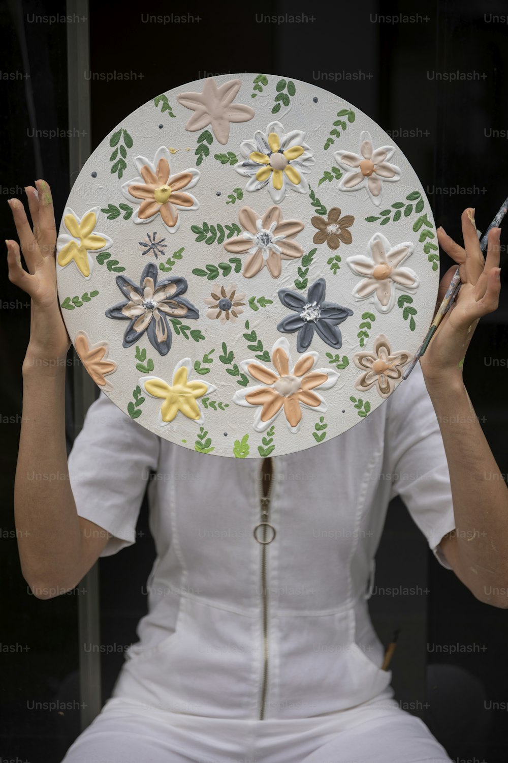 uma mulher em um vestido branco segurando uma placa decorativa