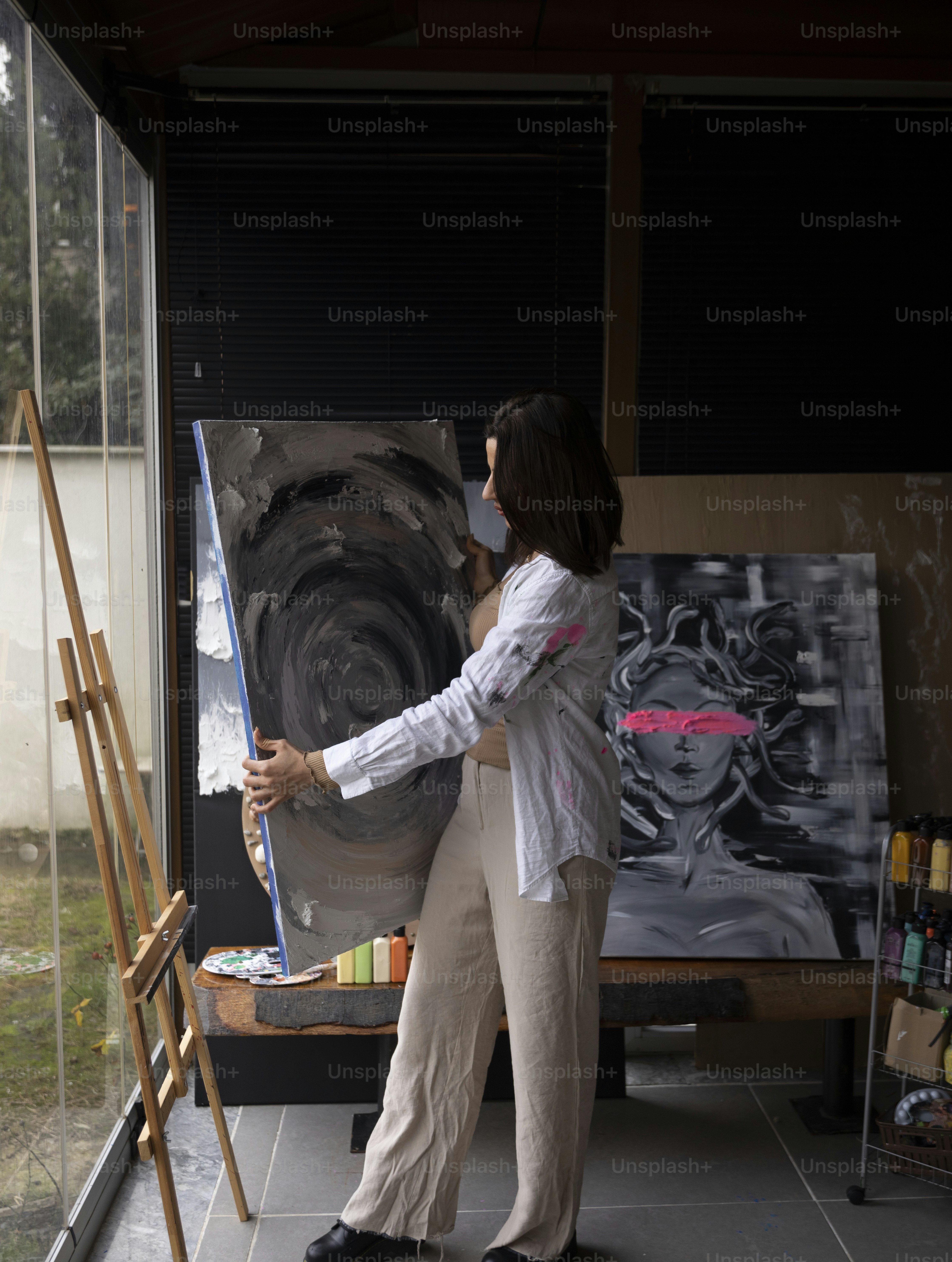 a woman is painting a picture on a easel