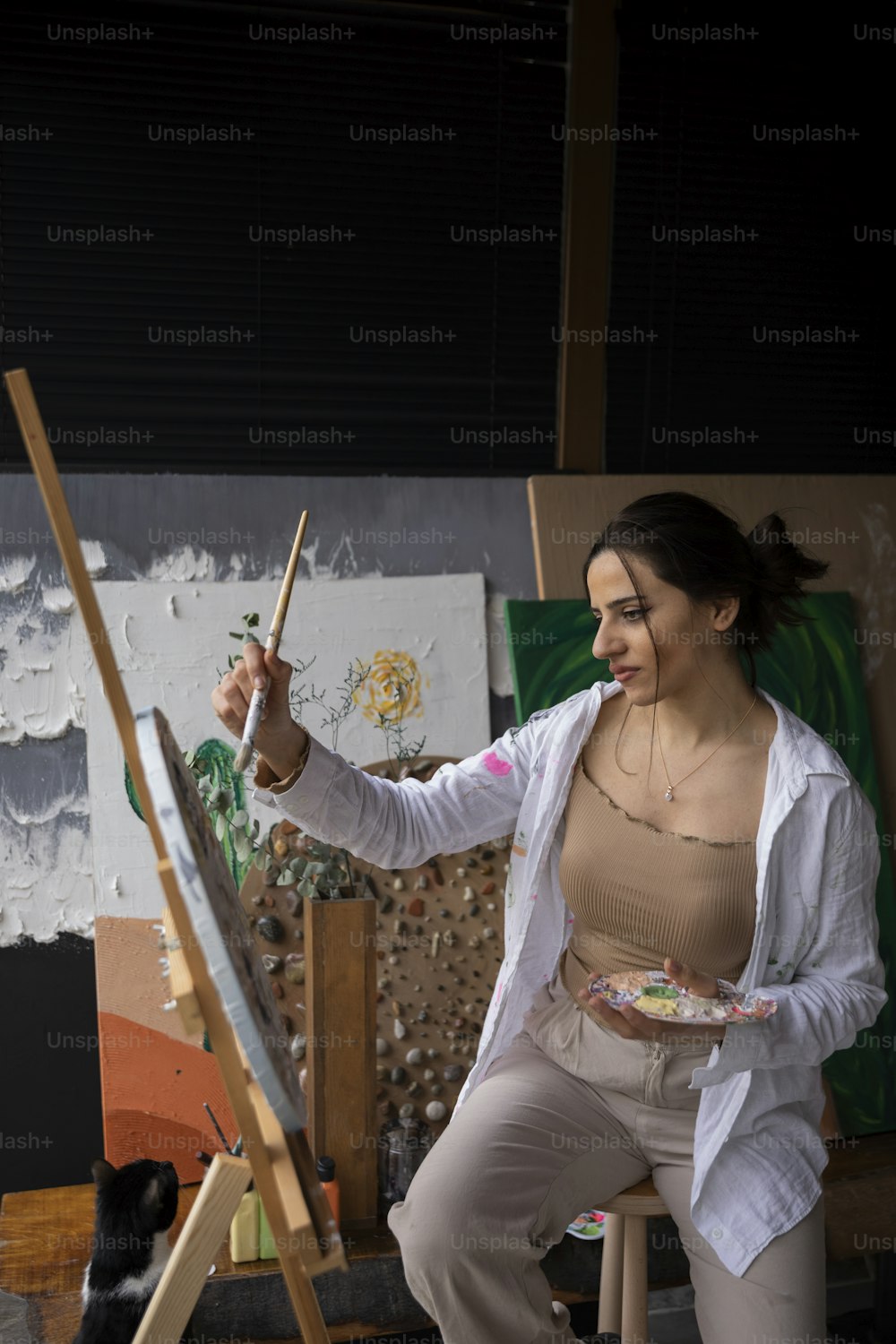 a woman holding a paintbrush and a palette