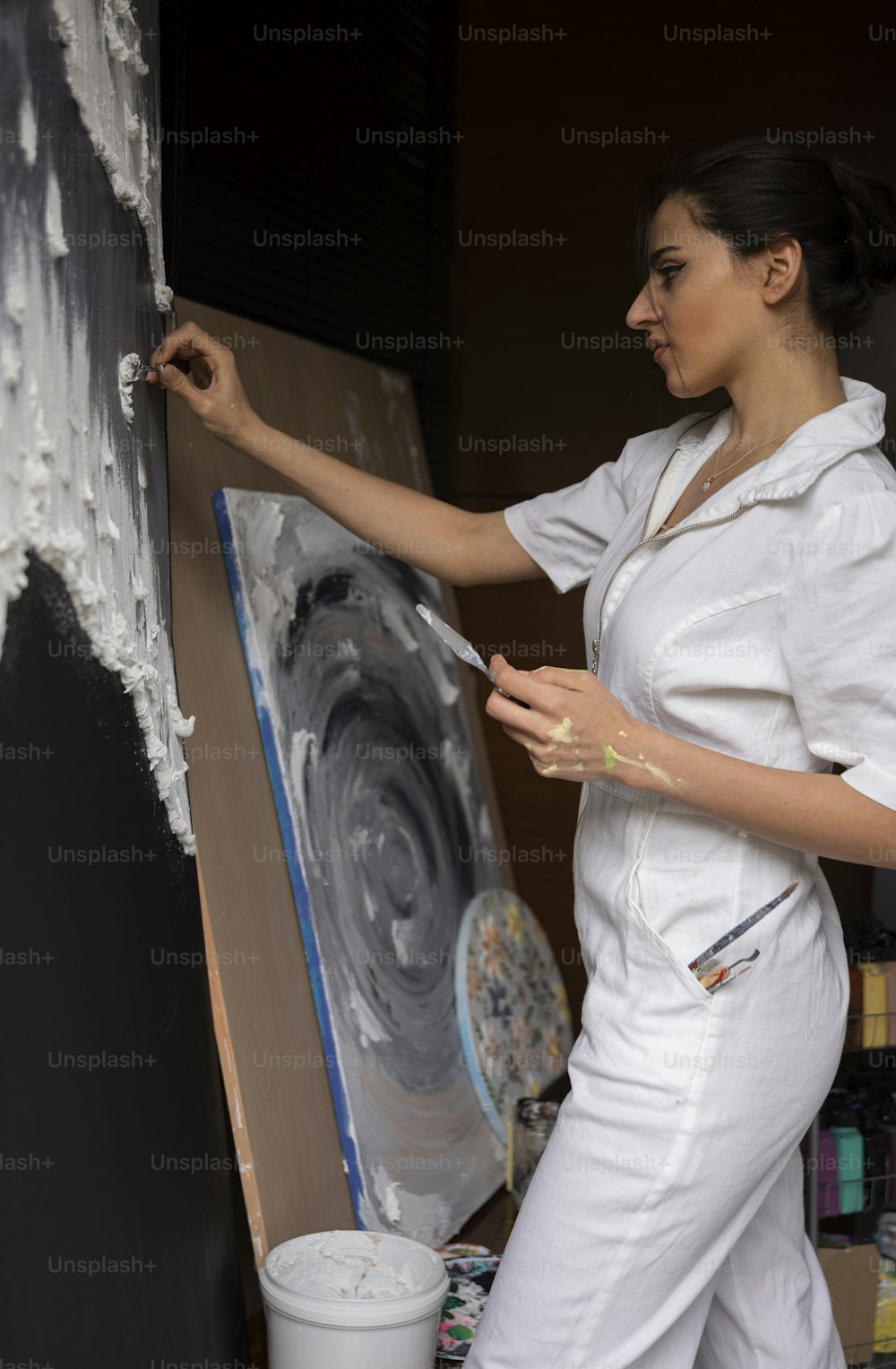 Una mujer está pintando un cuadro en un lienzo