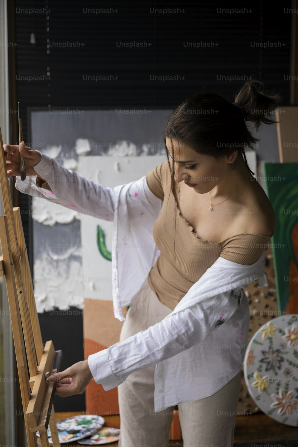 Eine Frau malt ein Bild auf eine Staffelei