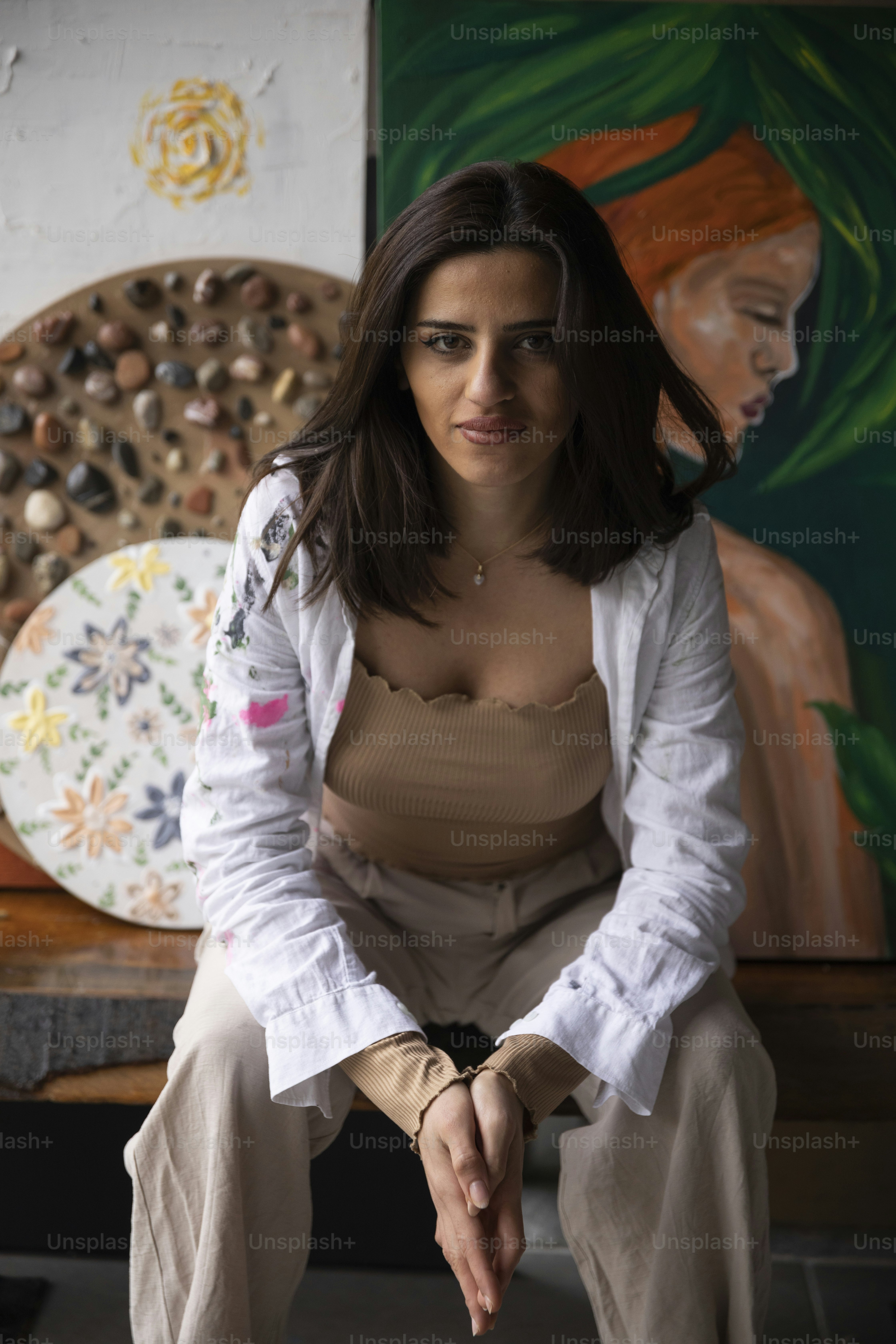 a woman sitting on a bench in front of a painting