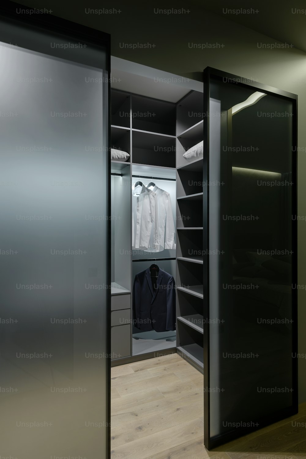 a walk in closet with a sliding glass door