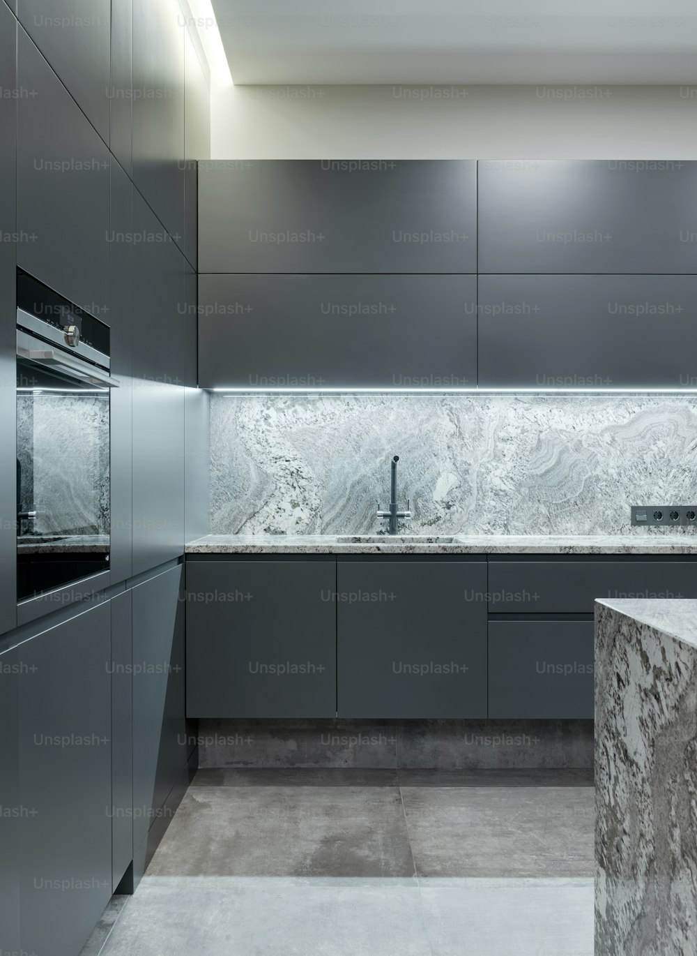 una cucina con piano di lavoro in marmo ed elettrodomestici in acciaio inox