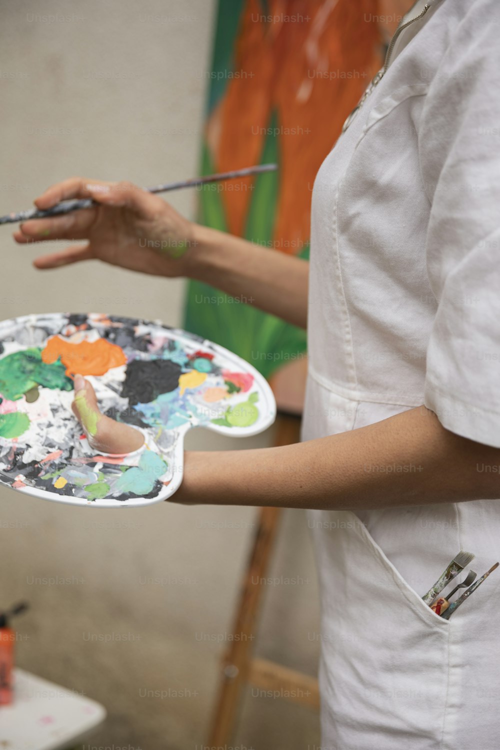 a woman holding a paintbrush and a paint palette