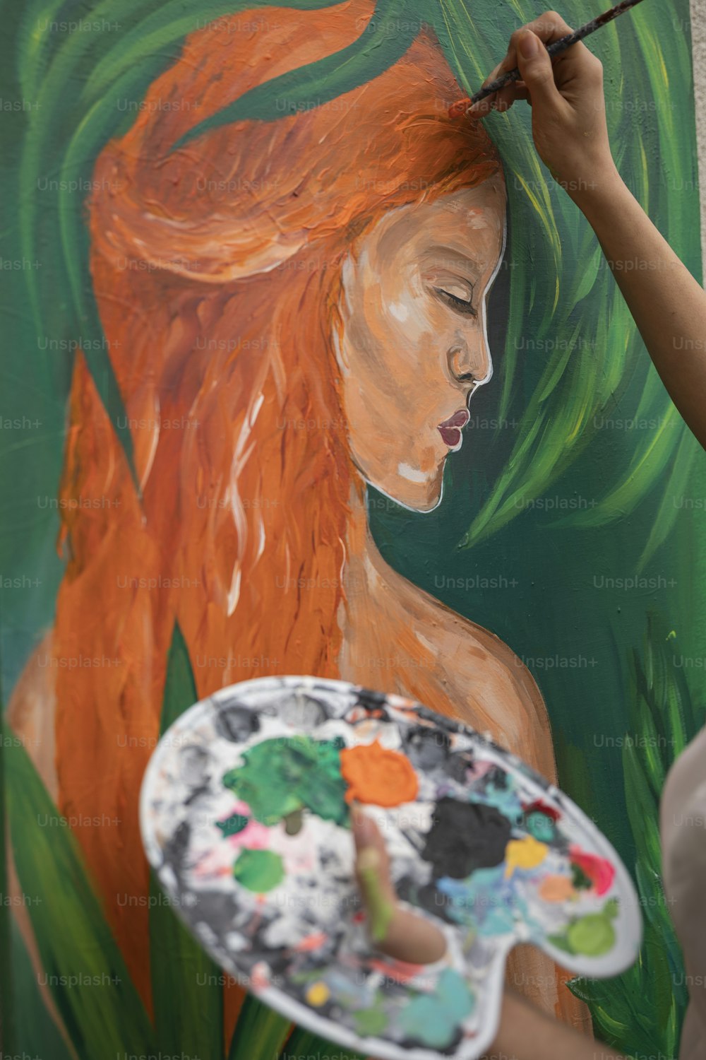 a woman is painting a picture on a wall