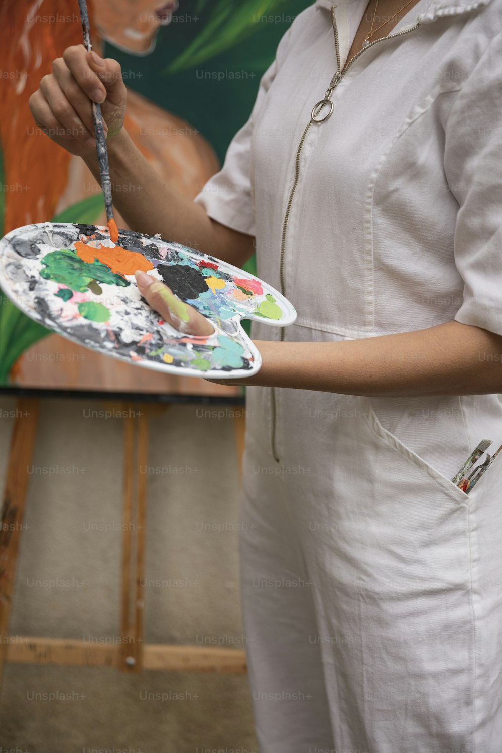 uma mulher segurando um prato com uma pintura sobre ele