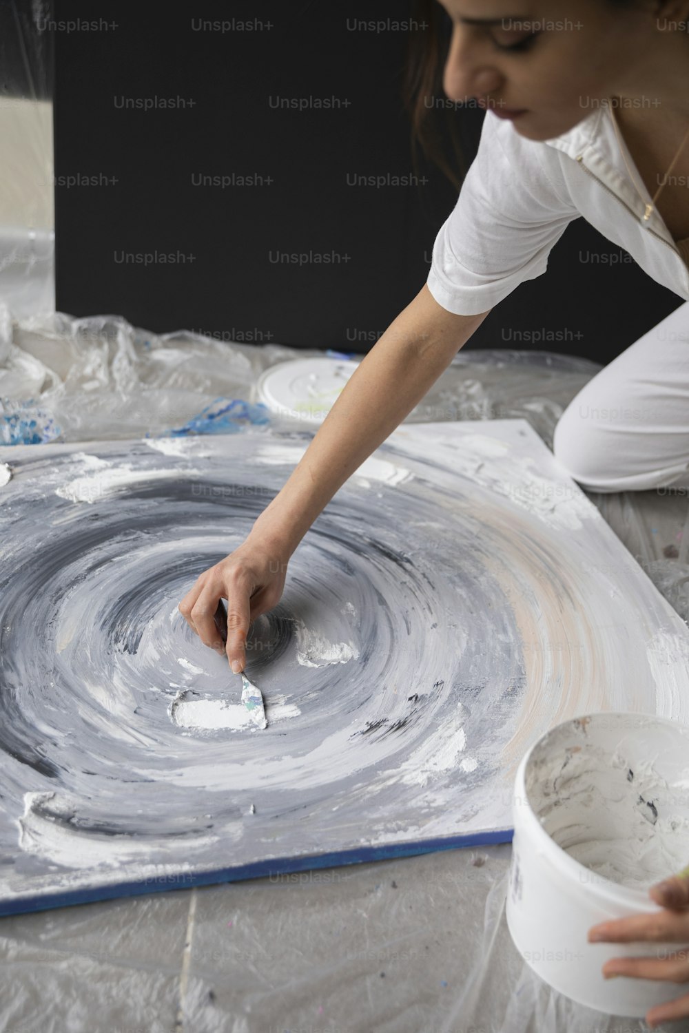 Una donna sta dipingendo un quadro su una tela