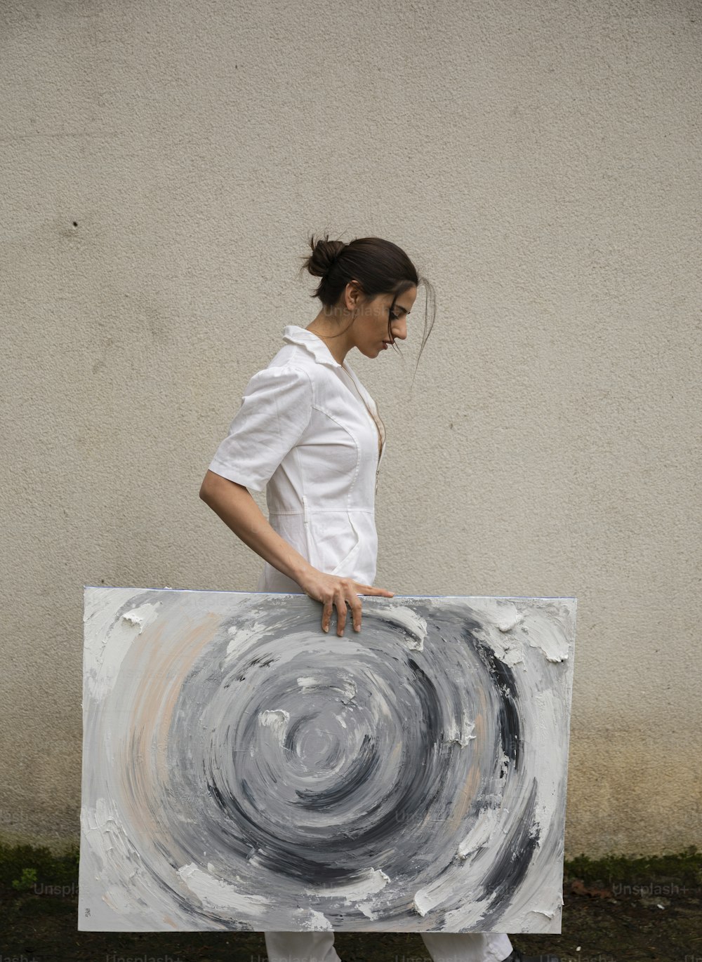 Una mujer sosteniendo una gran obra de arte