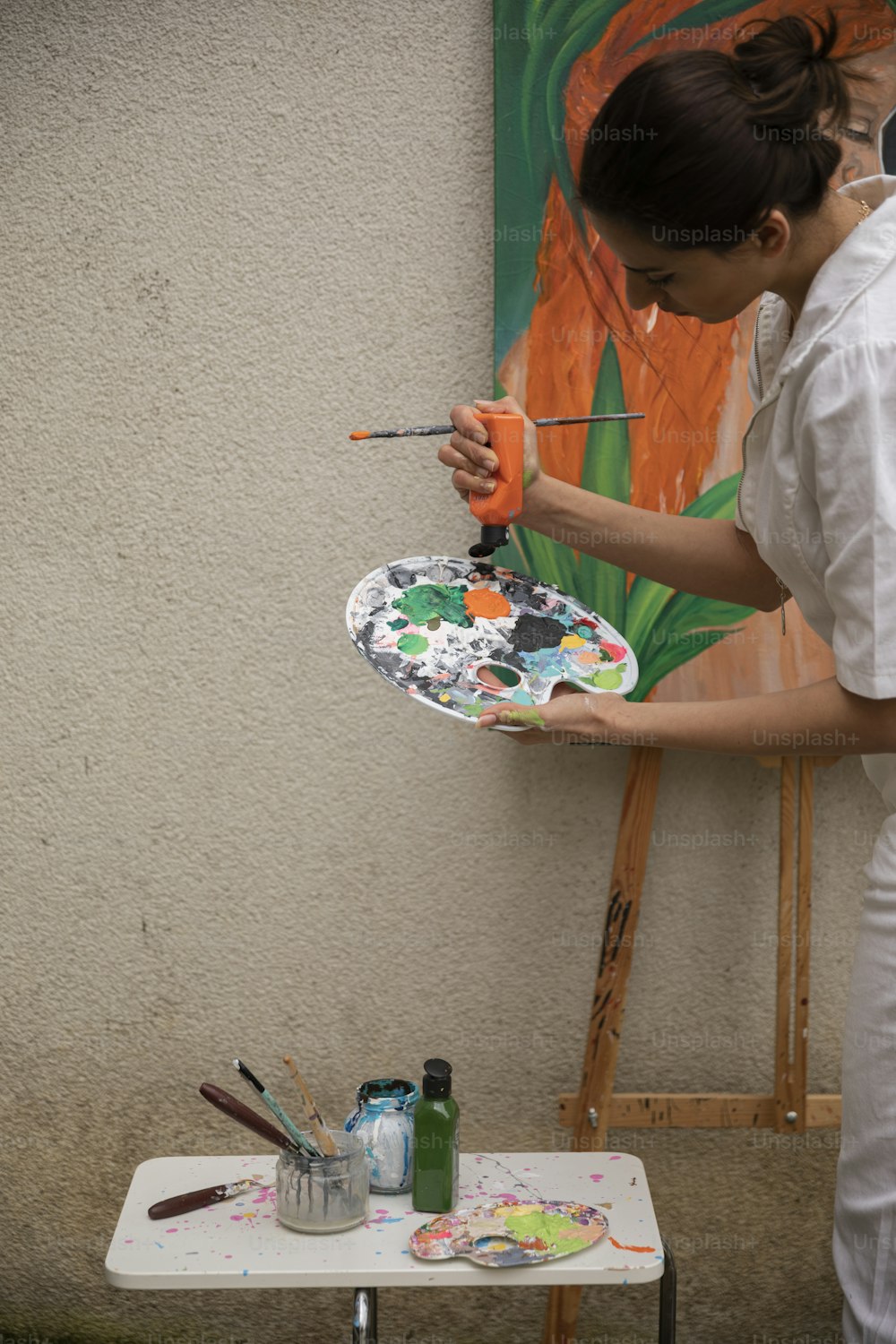 a woman is painting a picture on a plate