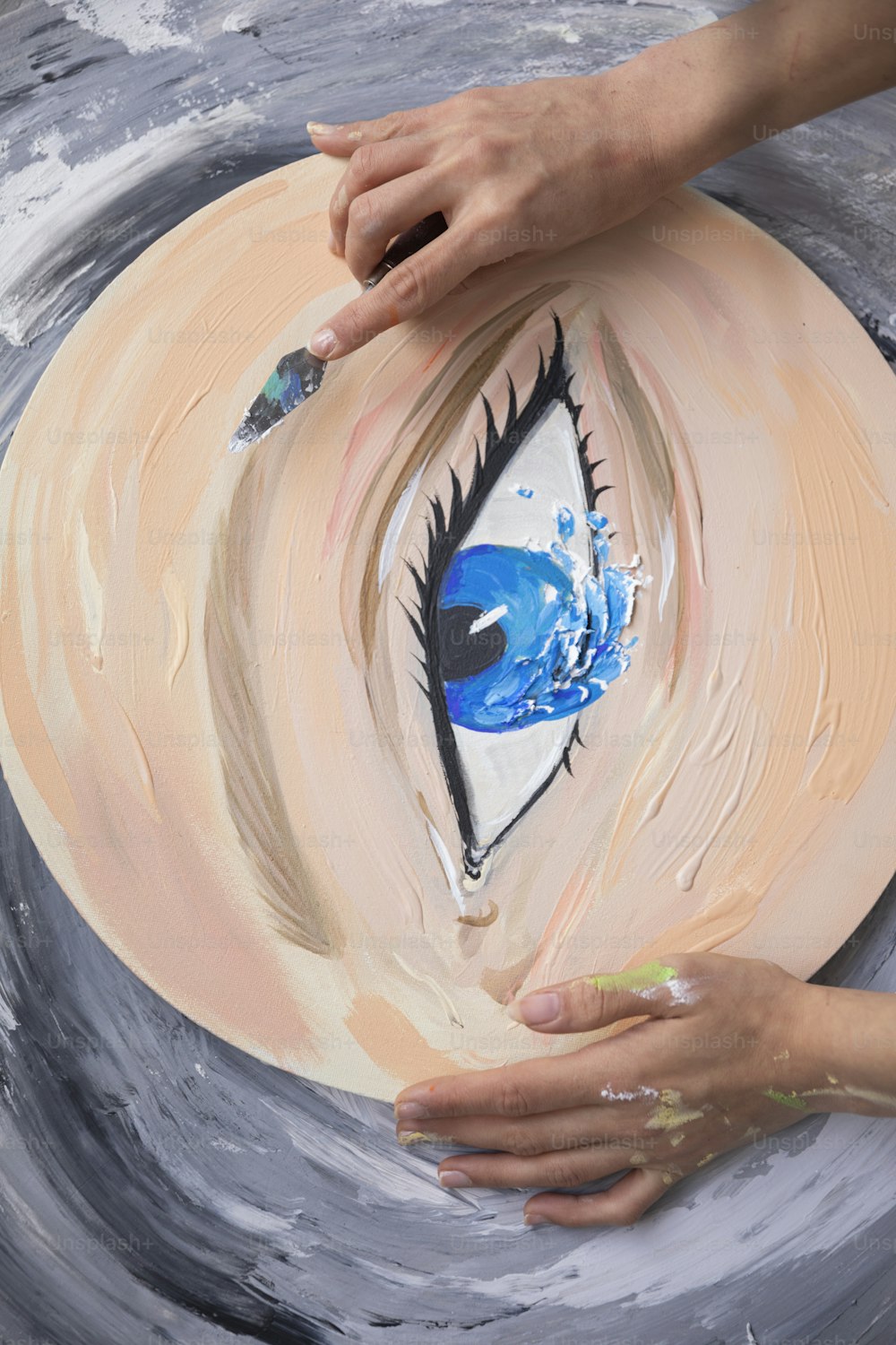 uma pintura de um olho azul sendo pintado em uma placa