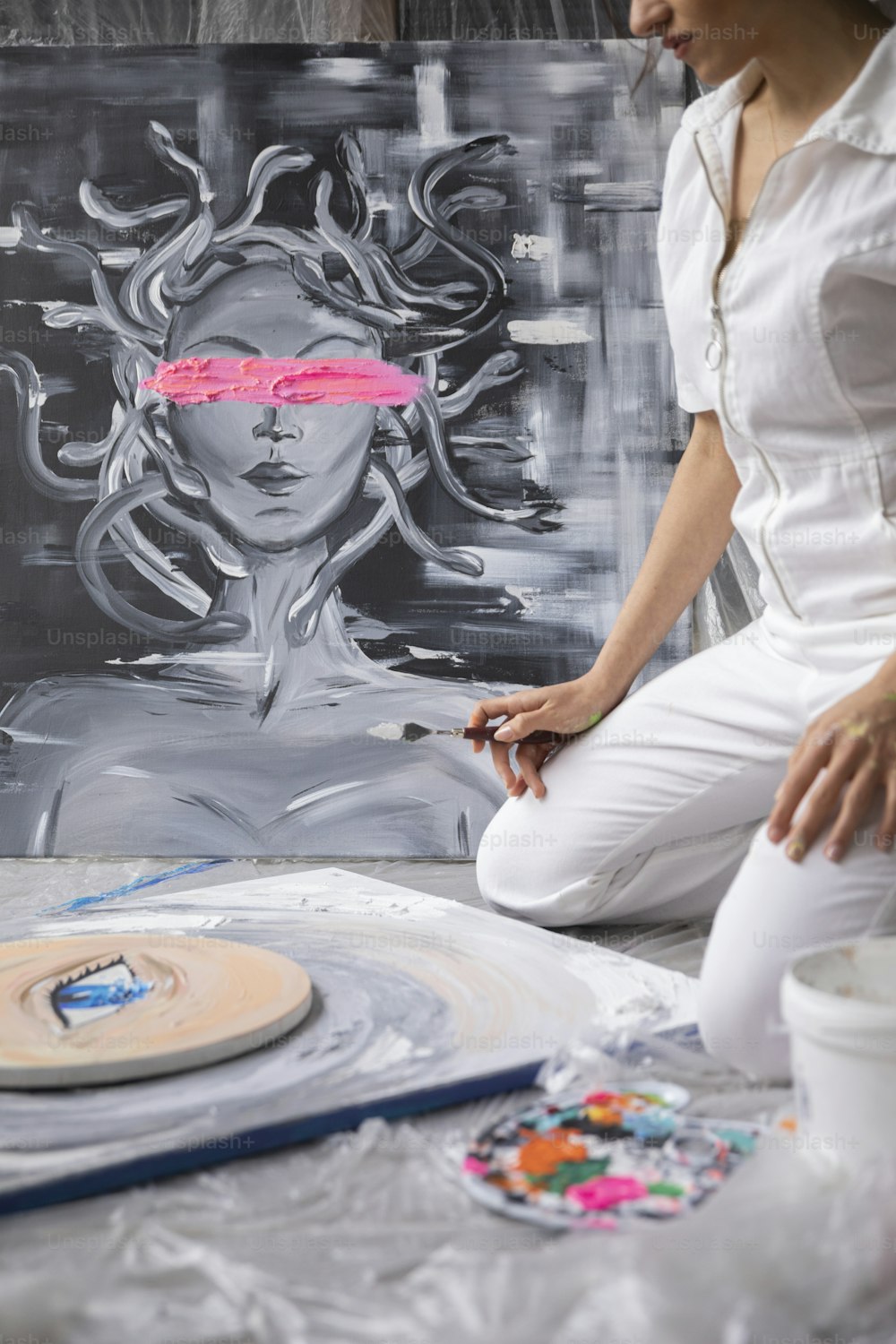 uma mulher sentada na frente de uma pintura