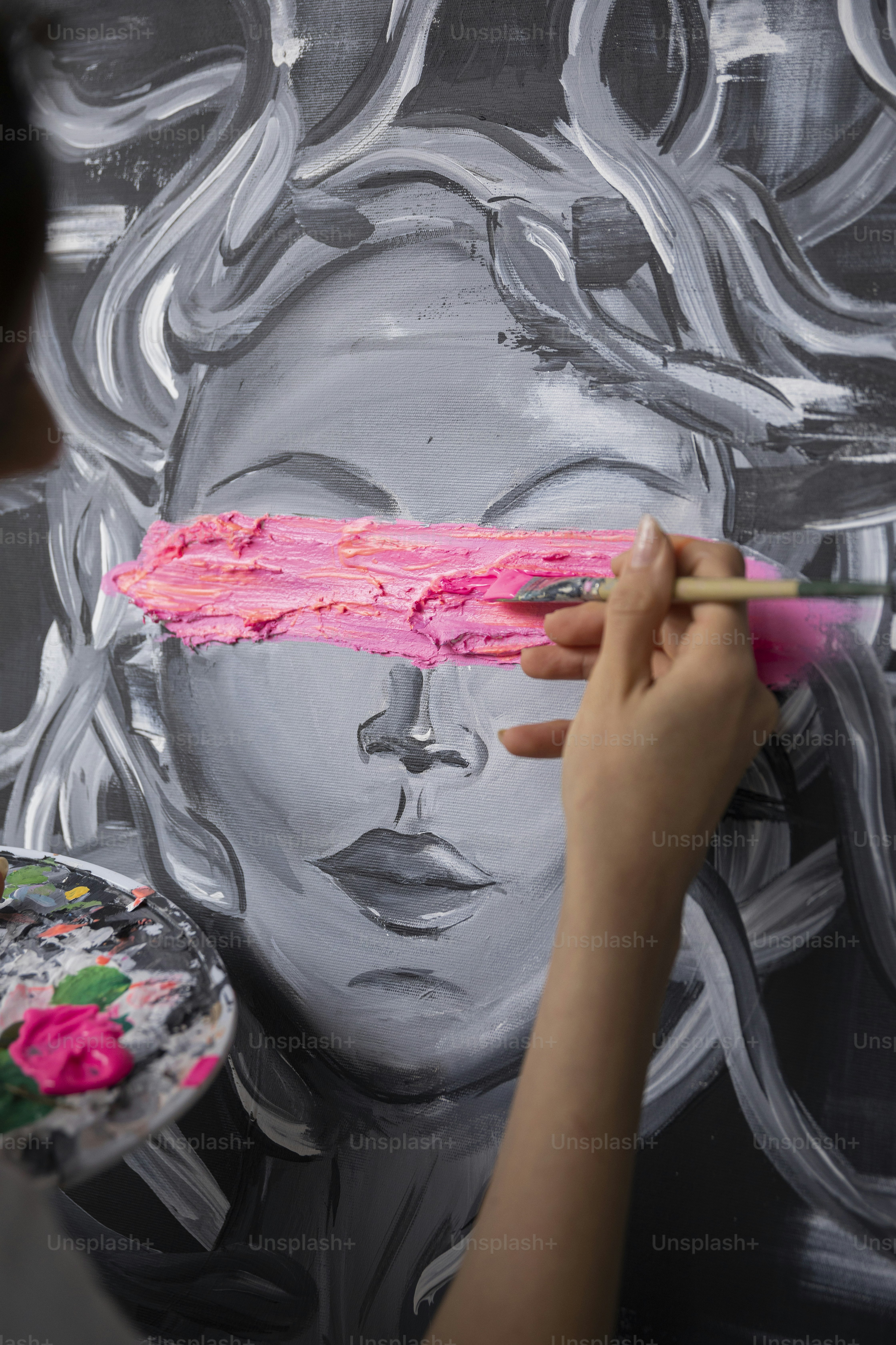 Une femme peint un visage sur un mur