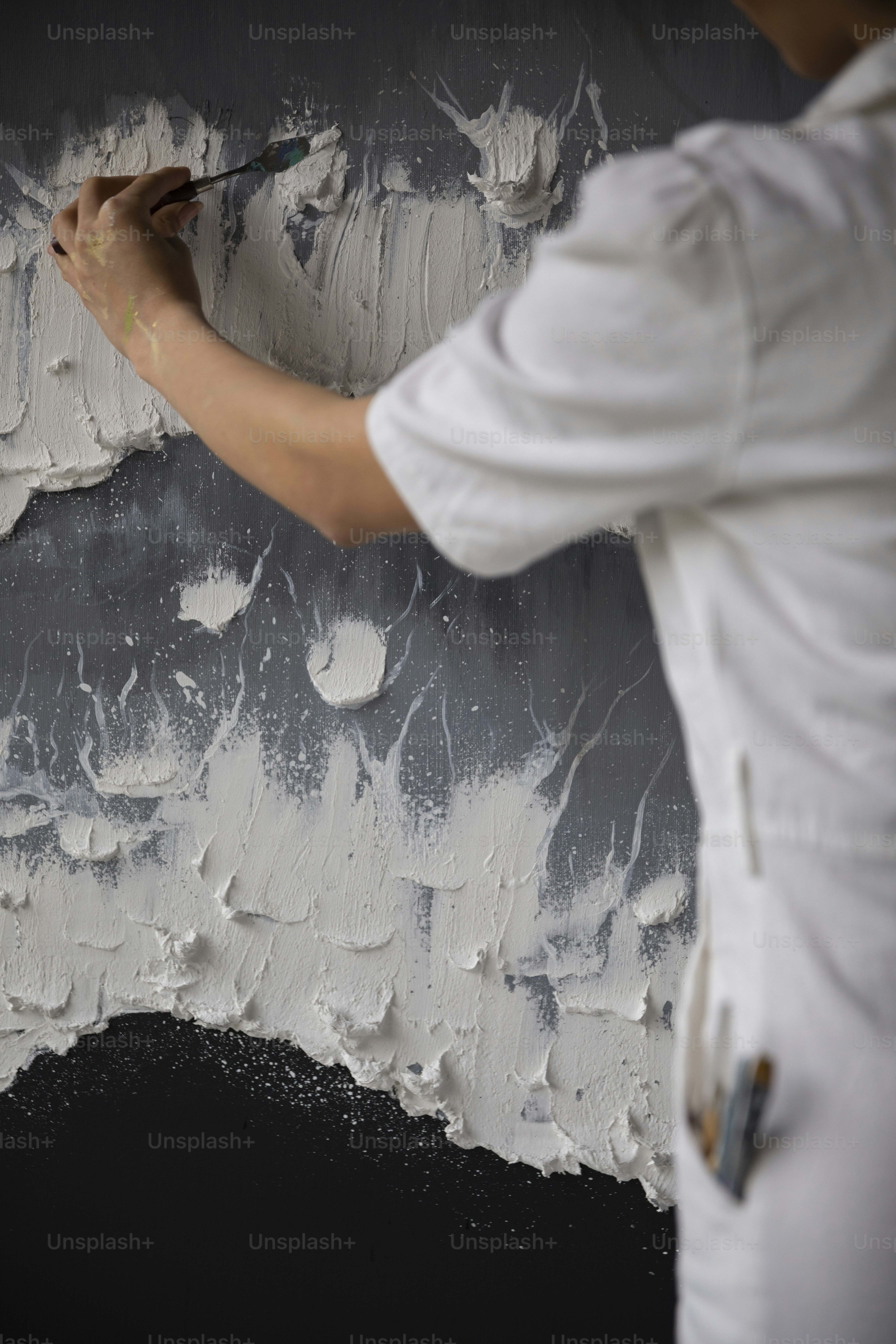 a man is painting a wall with white paint