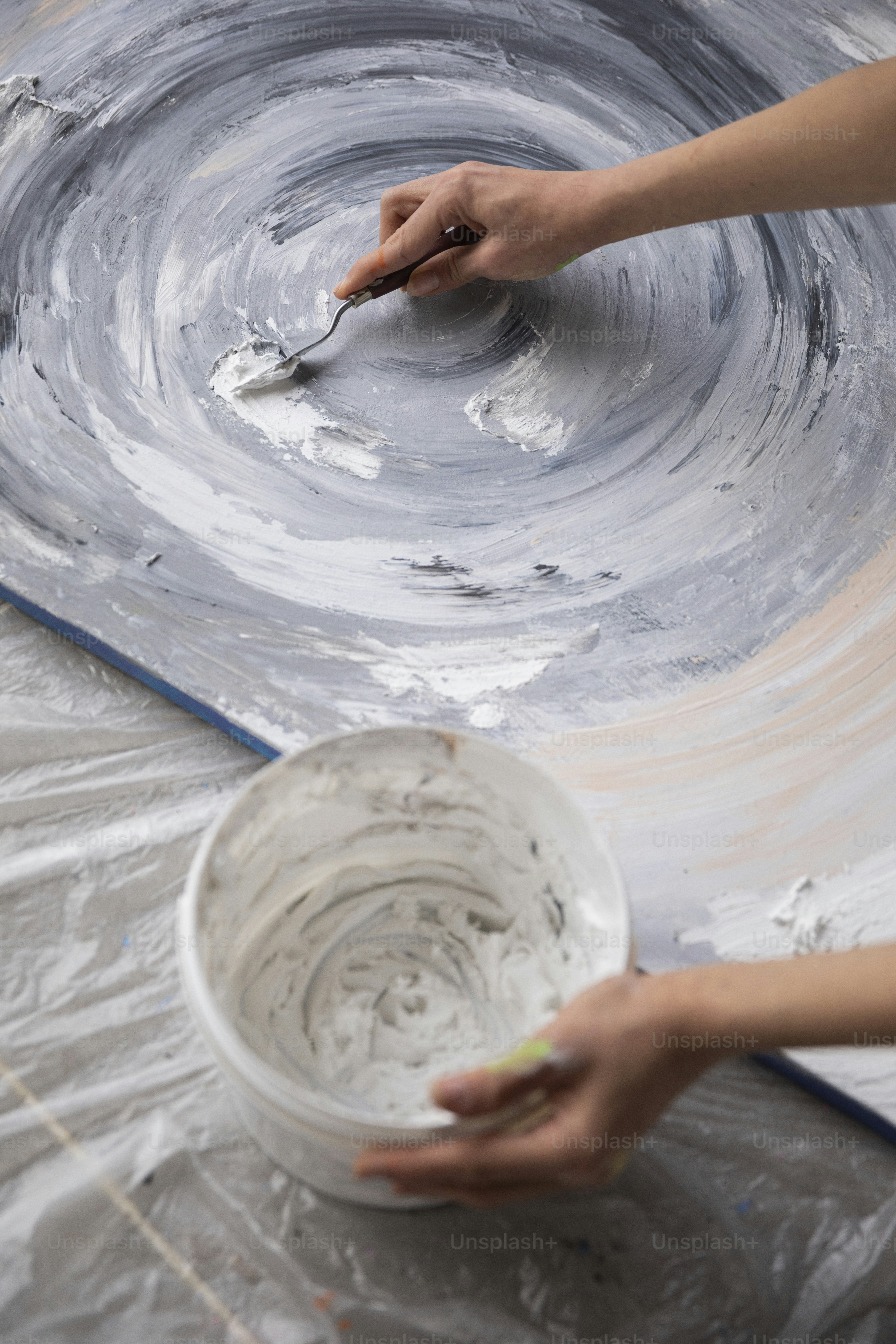 a person painting a bowl with a brush