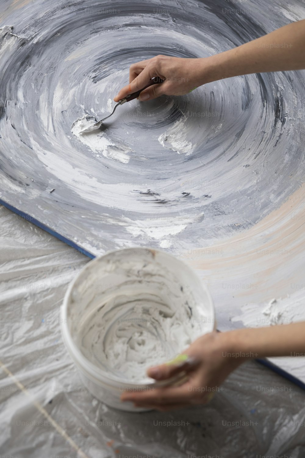 a person painting a bowl with a brush