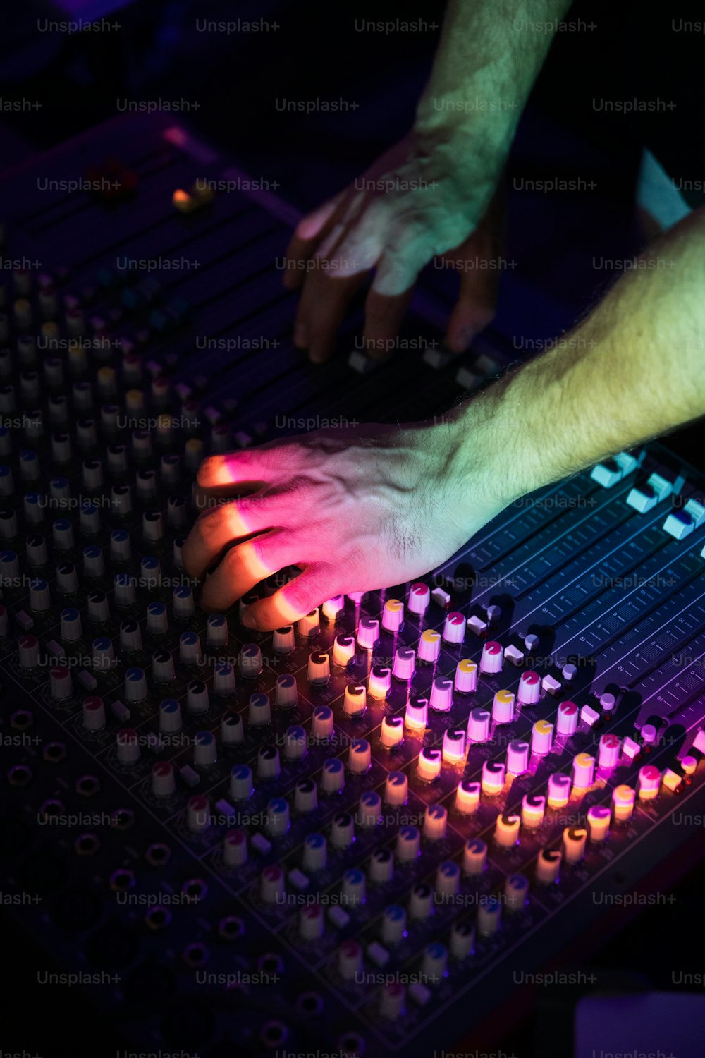 a person using a sound board in a dark room