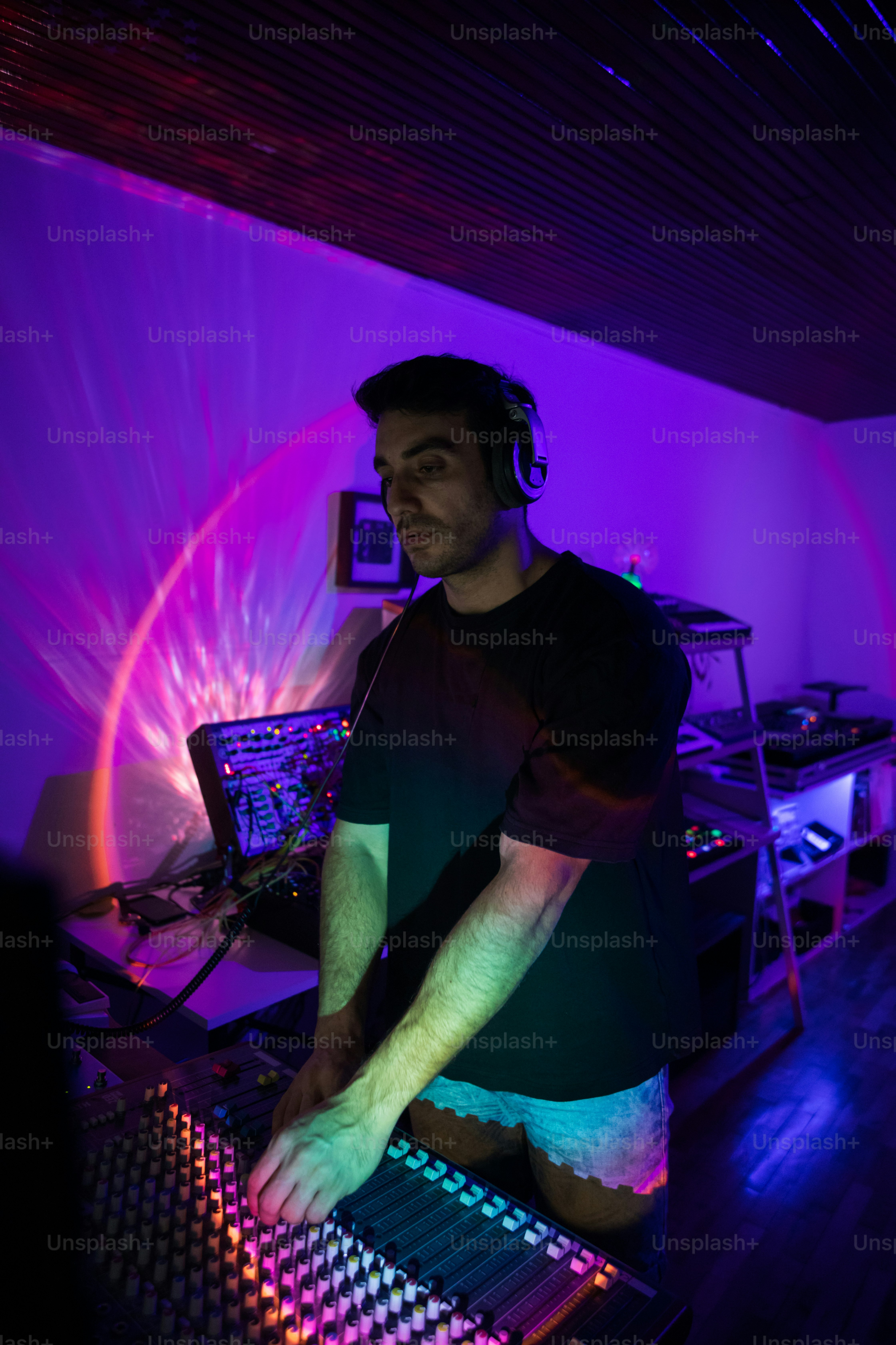 Ein Mann, der vor dem Mixer eines DJs steht