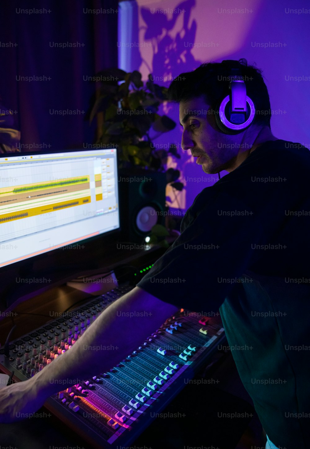 Un homme portant des écouteurs devant un ordinateur