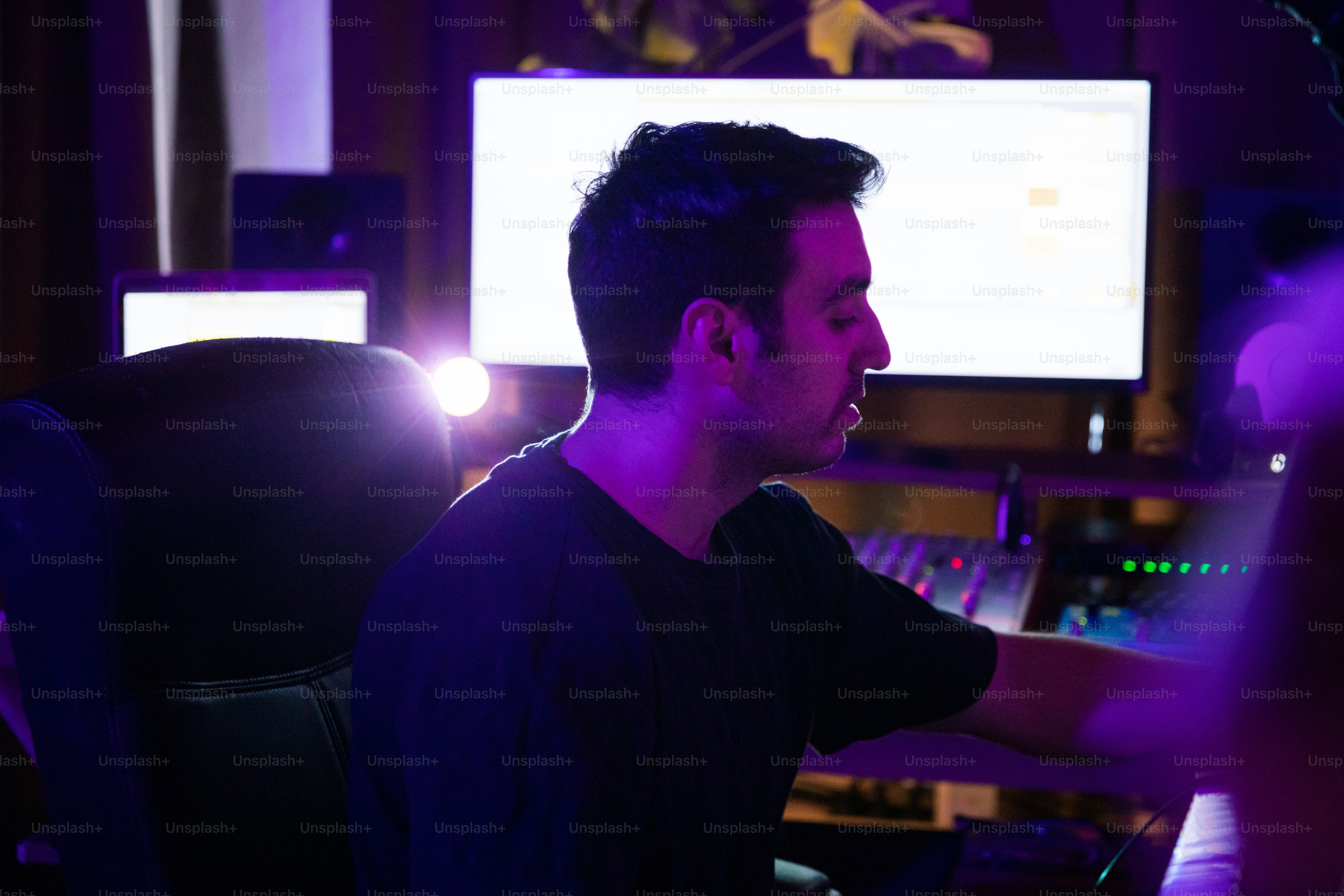 um homem sentado na frente de um monitor de computador