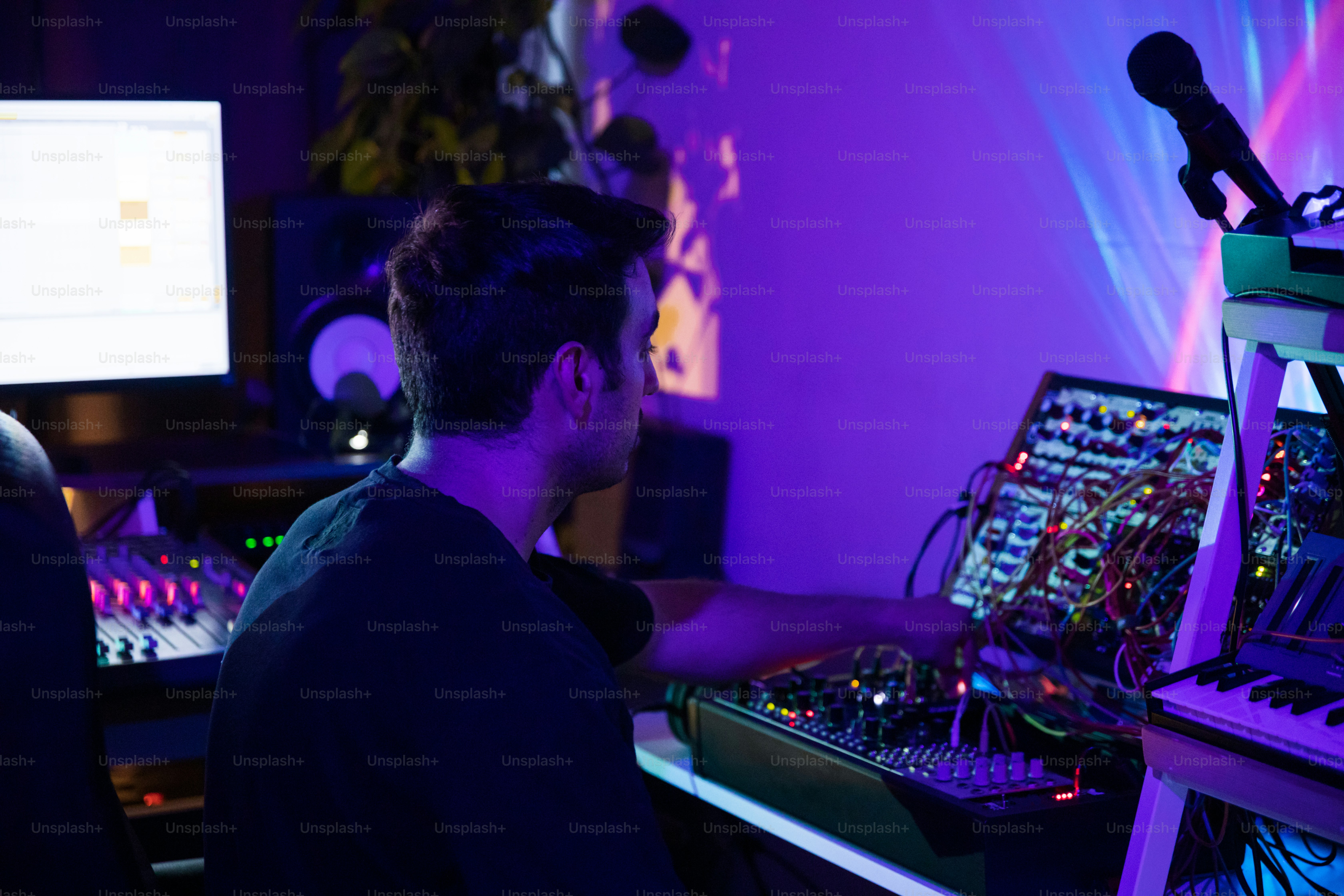 a man sitting in front of a computer in a recording studio