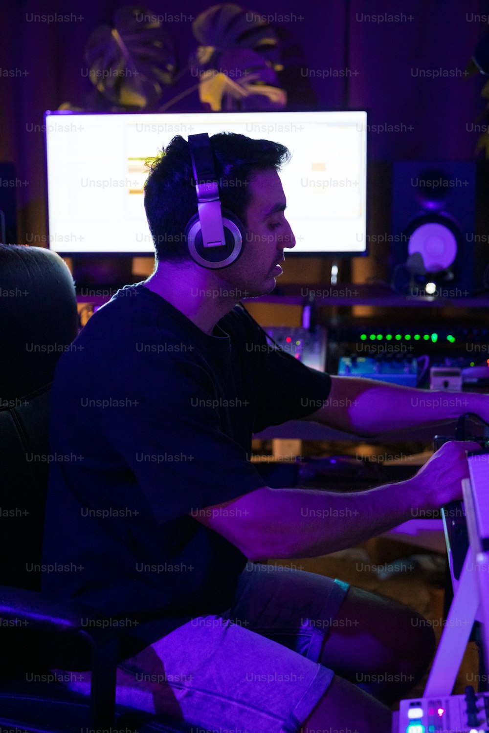 Ein Mann sitzt mit Kopfhörern vor einem Computer