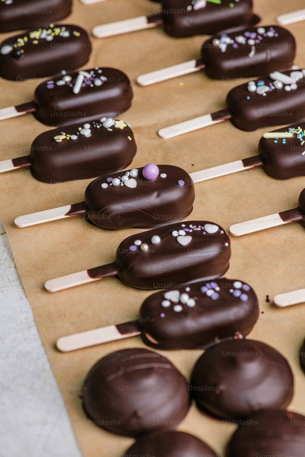 uma mesa coberta com donuts cobertos de chocolate e marshmallows