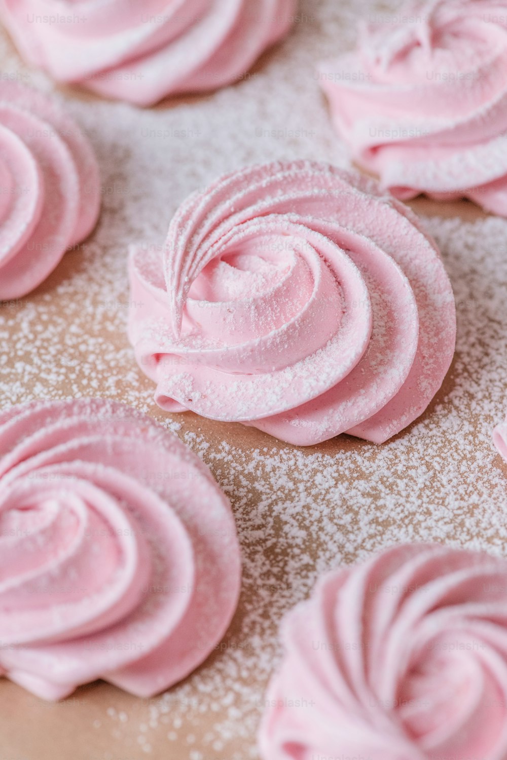 a close up of pink frosted cookies on a table