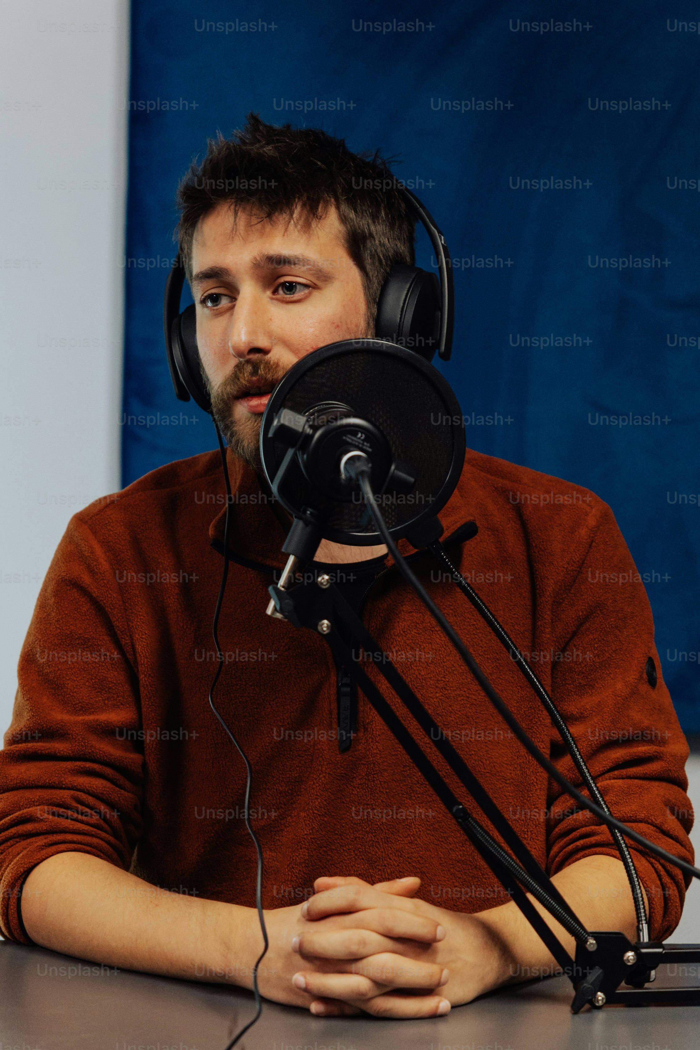 Un hombre con auriculares sentado frente a un micrófono
