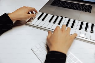 Una persona está tocando un teclado en una computadora portátil