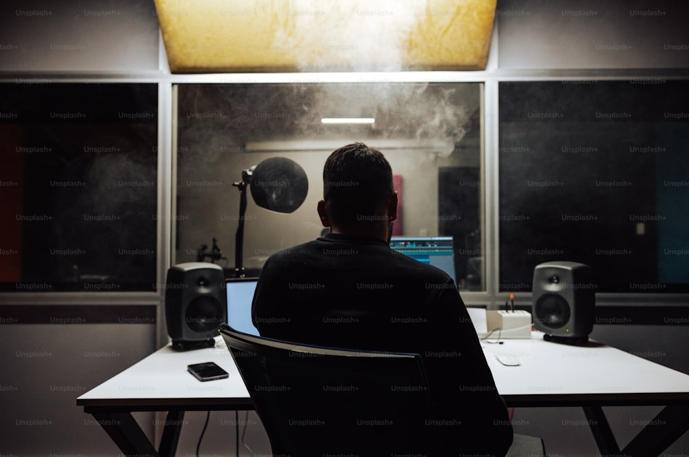 a man sitting at a desk in front of a computer