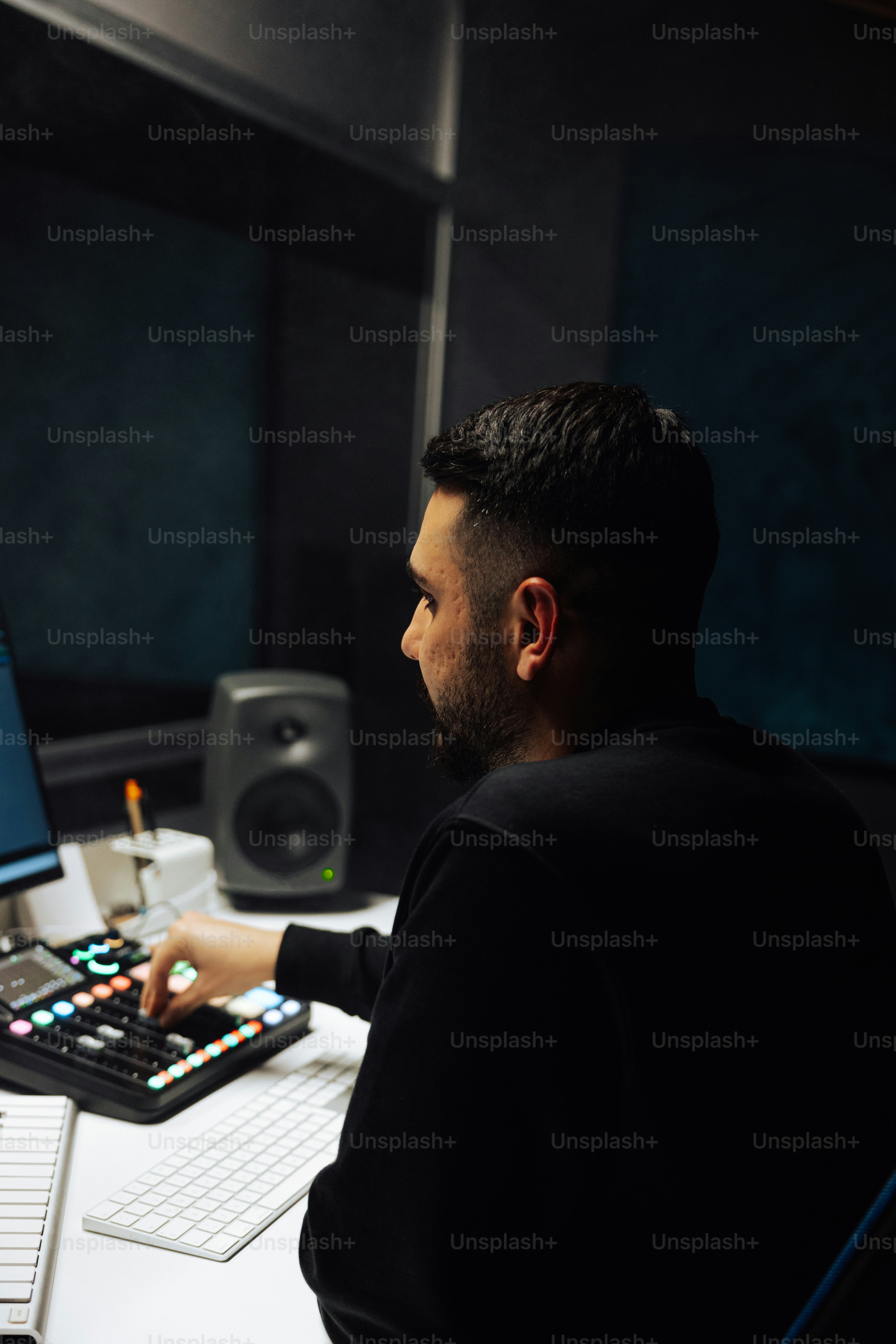 a man sitting at a desk with a keyboard and monitor