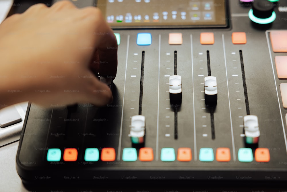 a hand is pressing buttons on a sound board