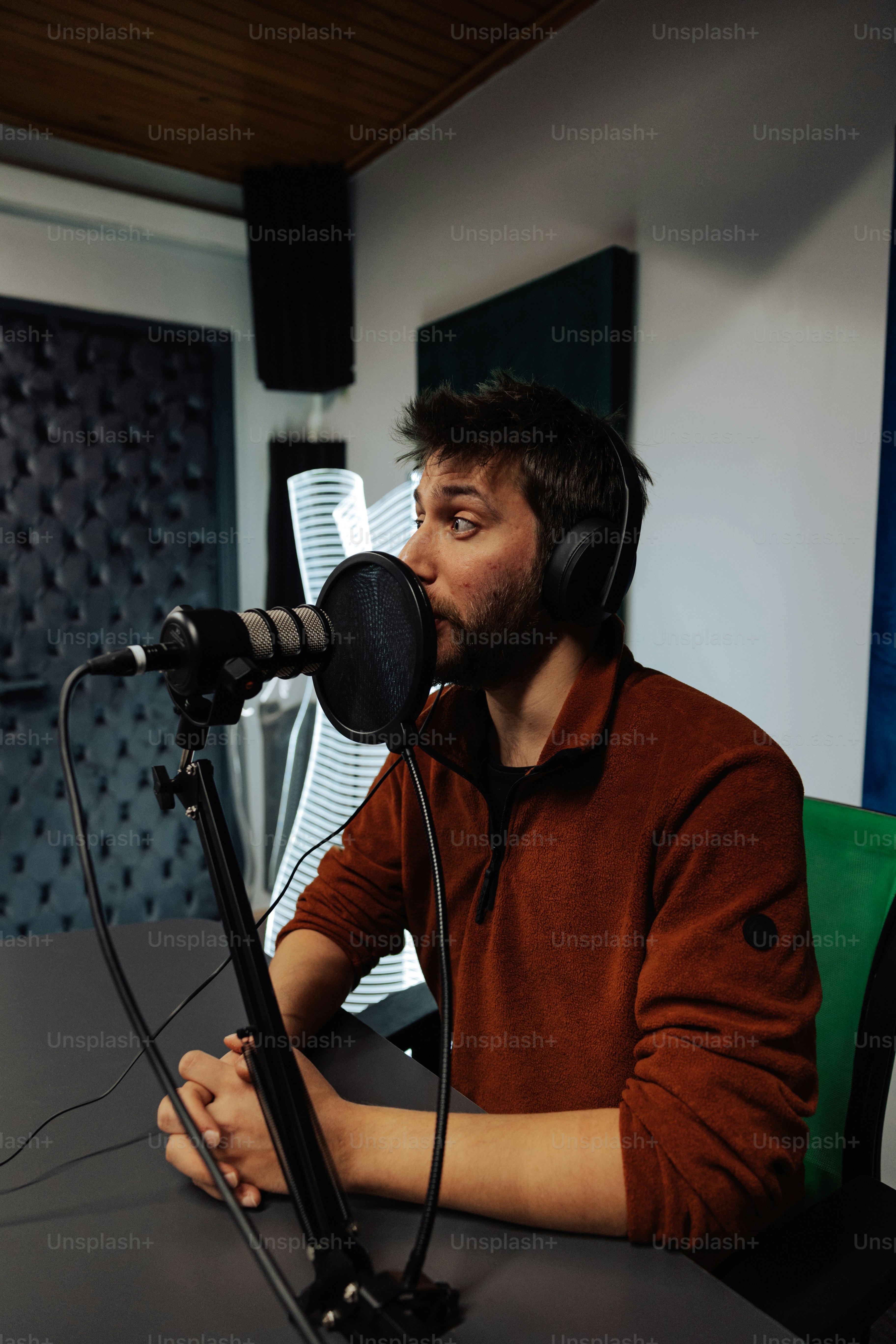 a man sitting in front of a microphone with headphones on