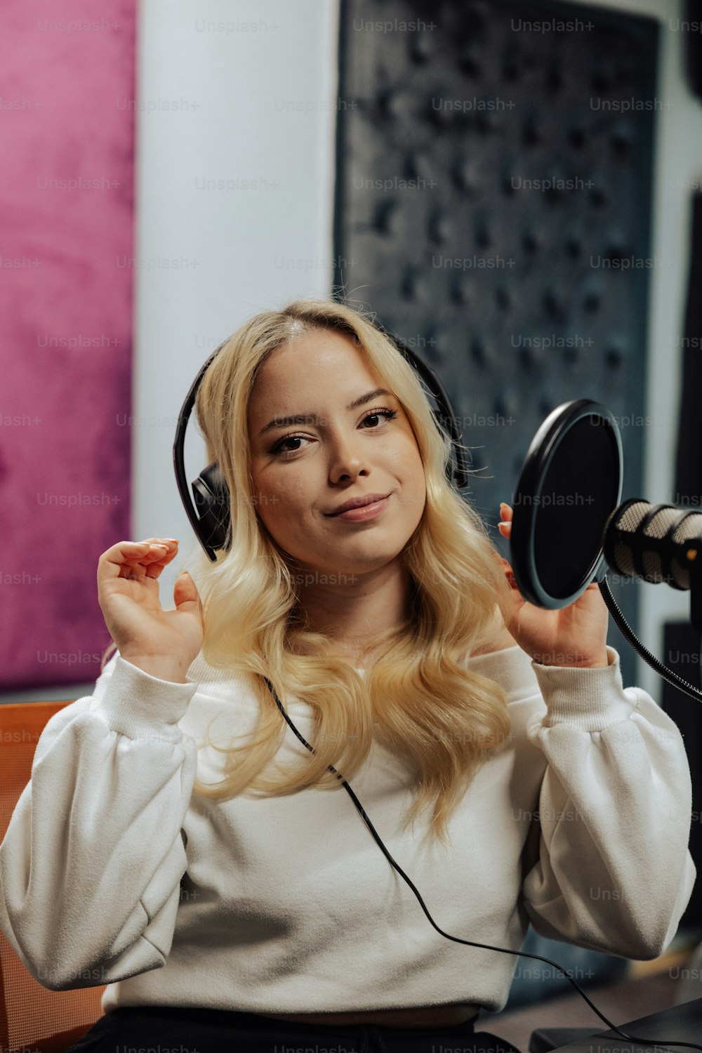 a woman with headphones sitting in front of a microphone