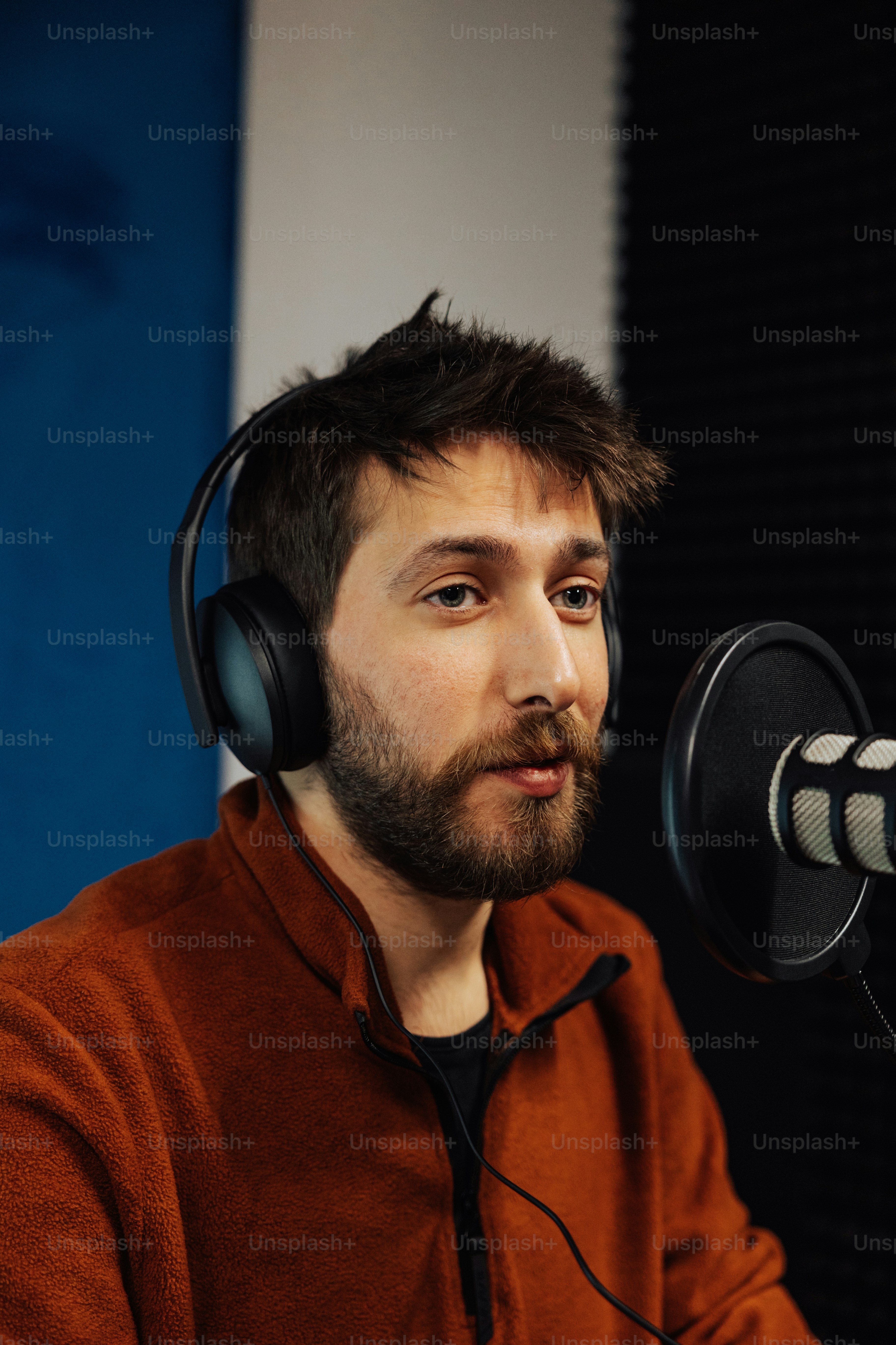 a man wearing headphones sitting in front of a microphone