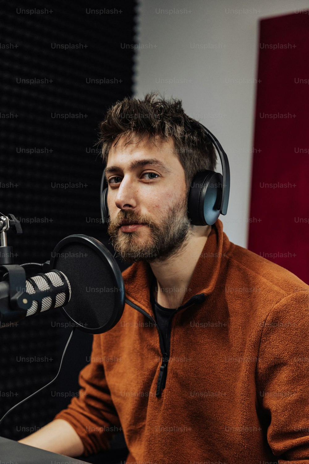 a man wearing headphones sitting in front of a microphone