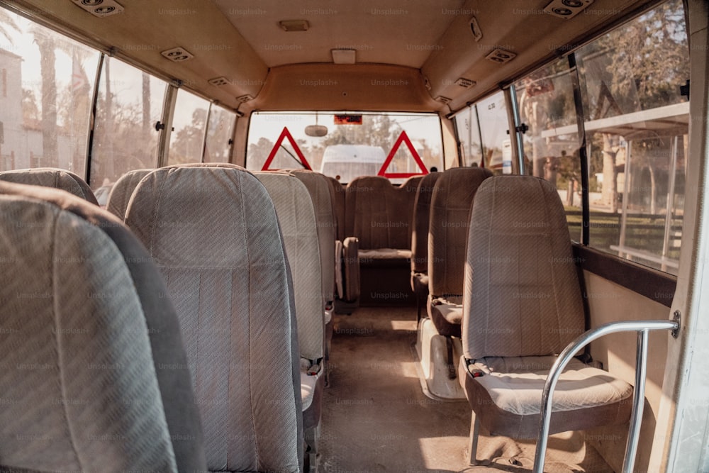 o interior de um ônibus com assentos e uma escada