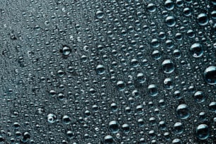 a close up of water droplets on a black surface