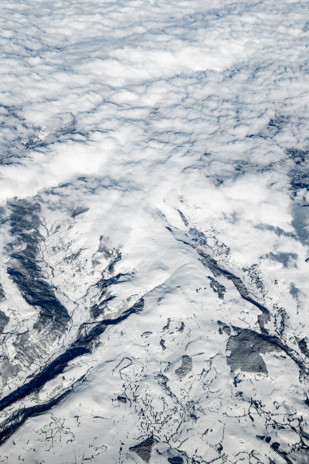 an aerial view of a snow covered mountain range