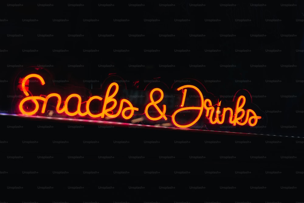 a neon sign that reads snacks and drinks