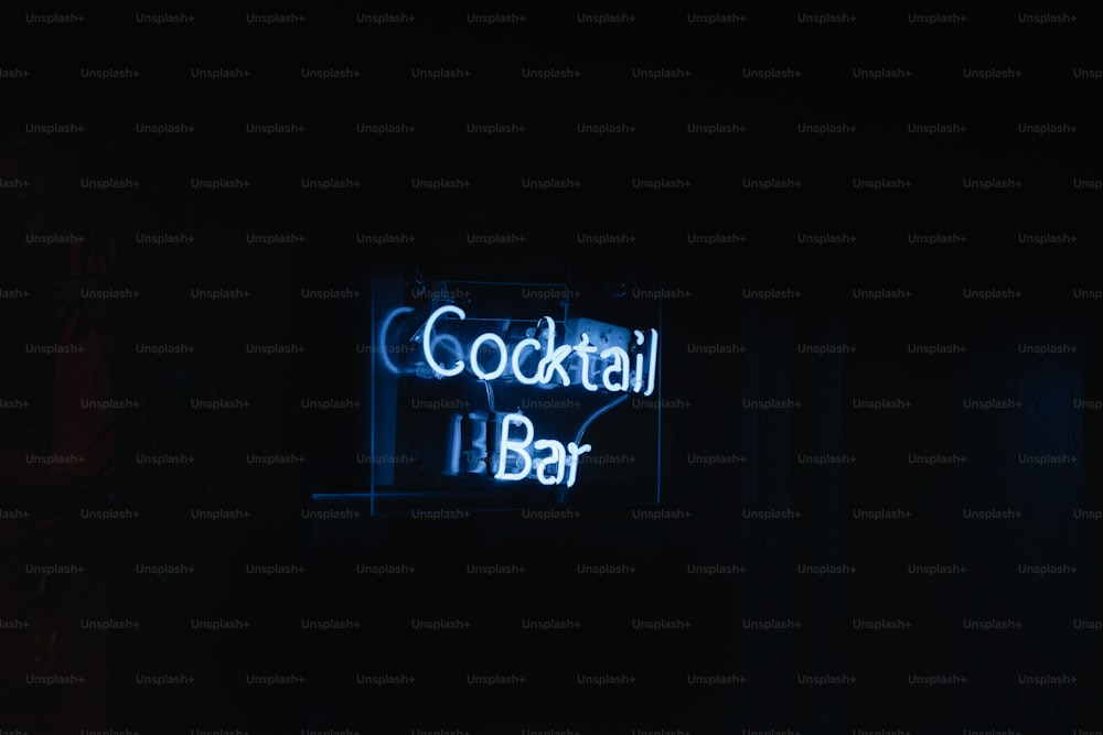 um letreiro de neon que diz bar de coquetéis no escuro