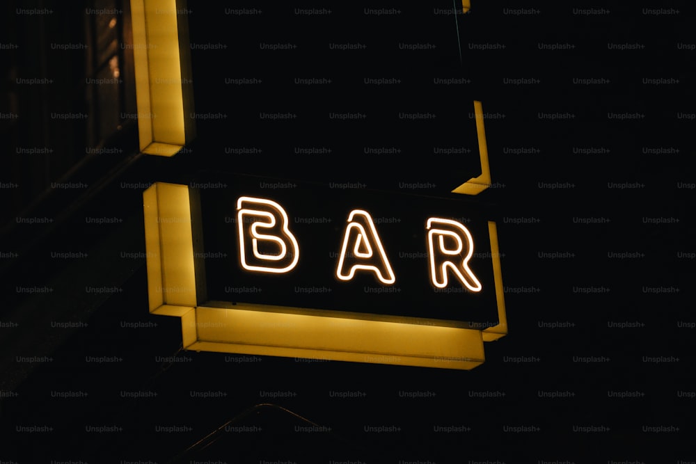 Un letrero de bar iluminado por la noche en la oscuridad