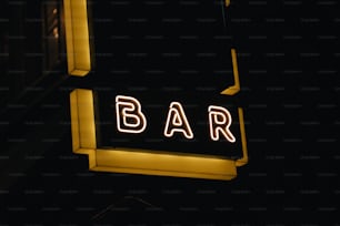 a bar sign lit up at night in the dark