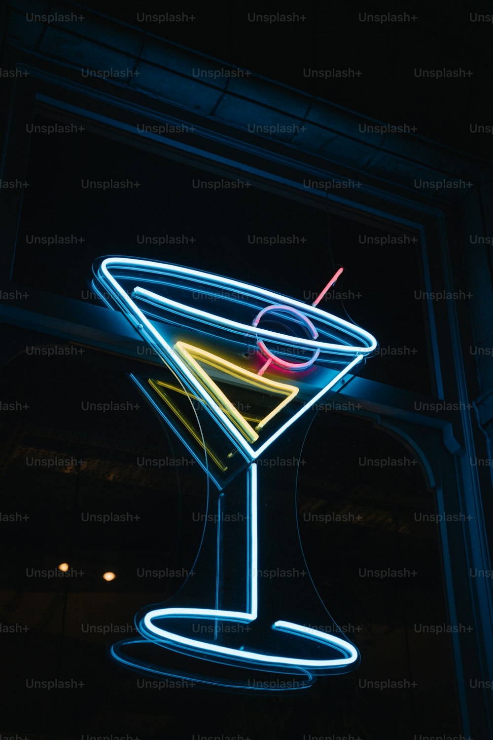 a lit up martini glass with a straw in it